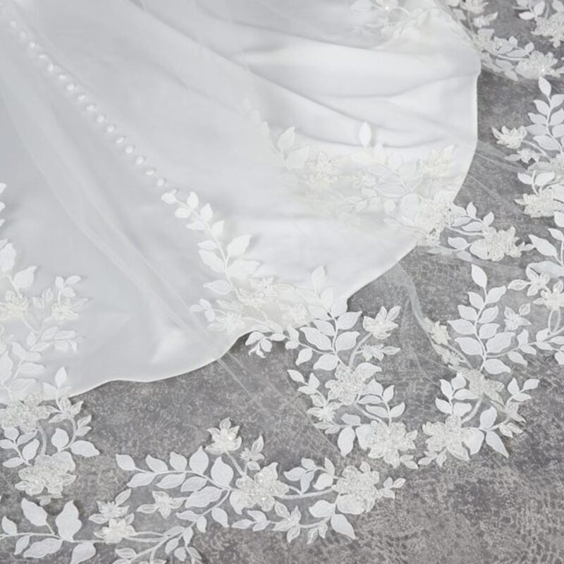 This incredible veil creates a lace train of unbelievably textured leaves, vines and flowers that follow you as you move. Each applique is densely embroidered, with 3D beaded florals and delicate floating chiffon petals that adorn the botanic vine shapes.