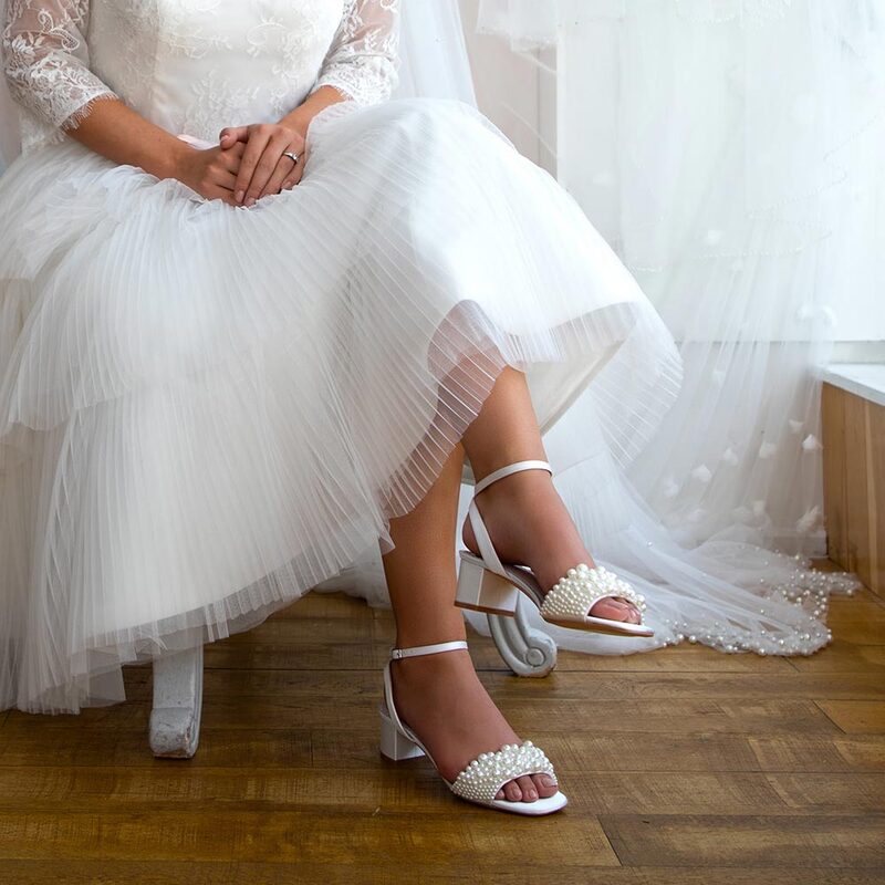 Block heeled ivory satin sandal with gorgeous pearl bar over the toes. Heel height 4.5cm. The perfect low heeled summer bridal sandal.
