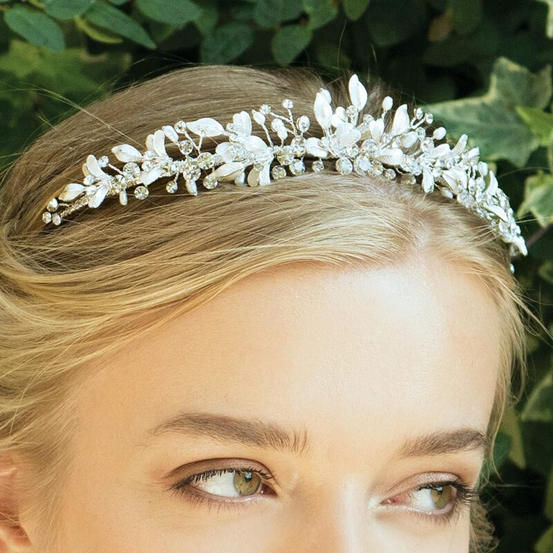A very pretty, feminine bridal tiara. Sparkling solitaire cut stones and ivory pearls are interwoven in a beautiful design with hand enamelled flowers and leaves forming a flattering focal point in the middle of the headdress.
