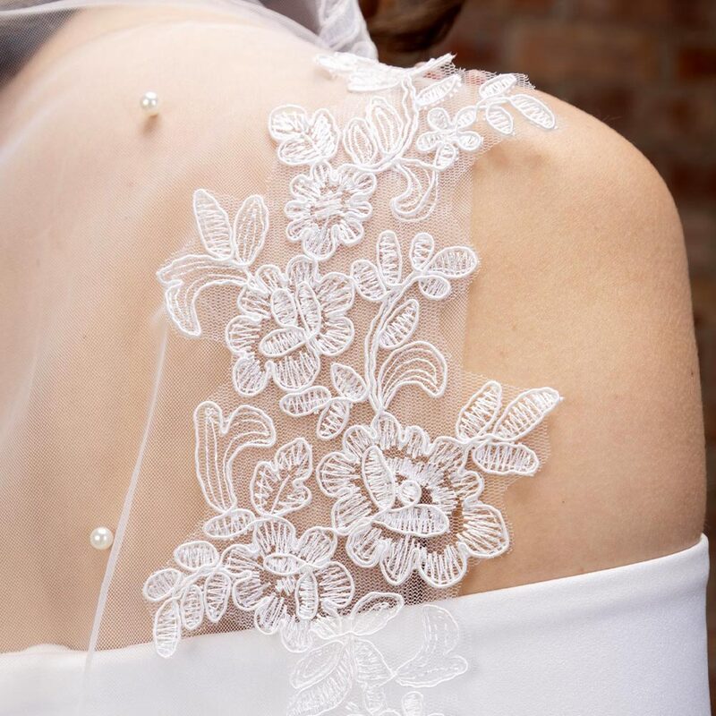This beautifully decorative waltz length veil is perfect for brides who want to add detail to their attire. Handmade from a single layer of soft ivory tulle this wedding veil is scattered with hundreds of luminous ivory pearls and finished with a gorgeous floral lace edging.
