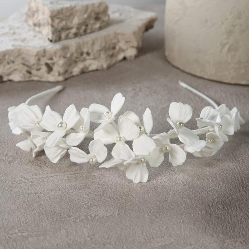 Modernise your bridal look with this statement 3D satin flower and pearl, wide headband. Luxurious satin has been used to create the cluster of flowers, which have been finished with pearl centres. Wired pearl sprigs surround the flowers, creating a lifelike floral arrangement.