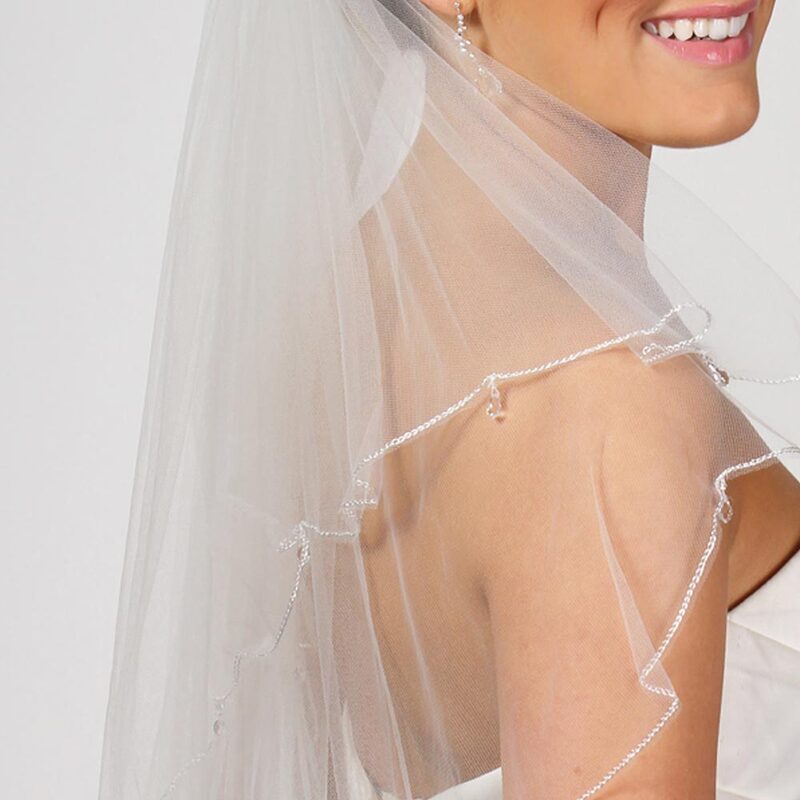Tulle veil finished with a delicate scalloped embroidery edge and delicate Swarovski crystal drops hand sewn between the scallops. This style is two tier, attached on a clear comb.